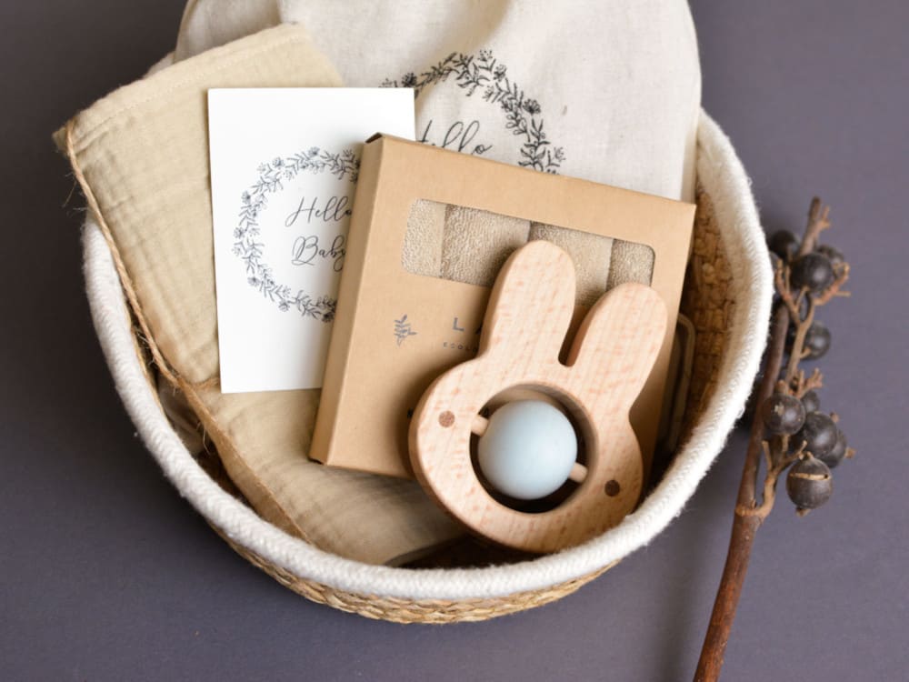 Babygeschenkset verpackt mit Holzgreifling und Grußkarte